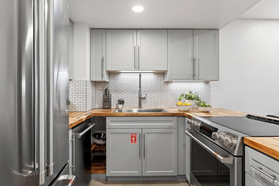Sleek, fully equipped kitchen with butcher-block counters and modern finishes.