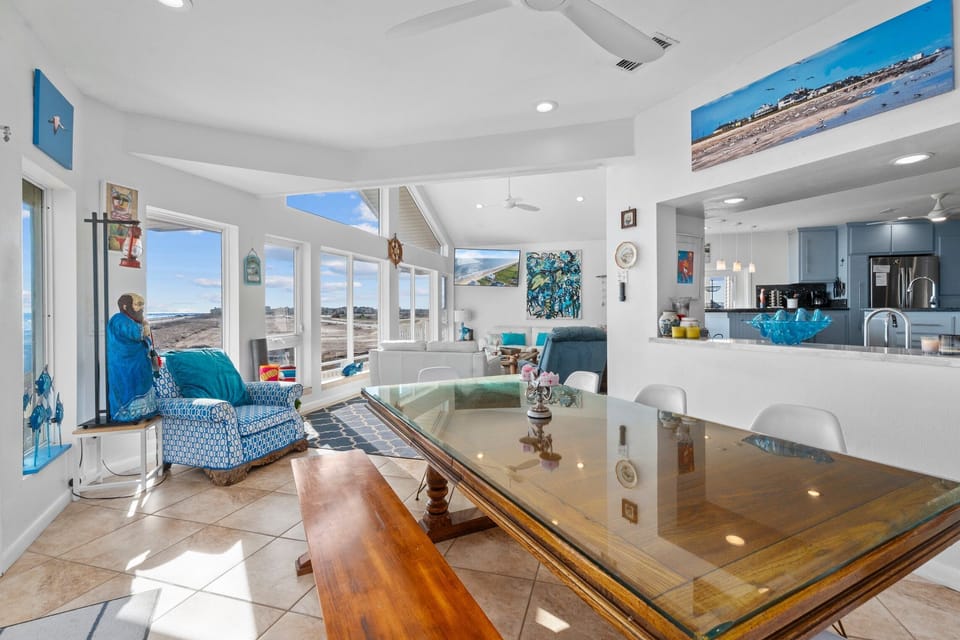 Large open living room with stylish coastal furnishings and direct ocean views.