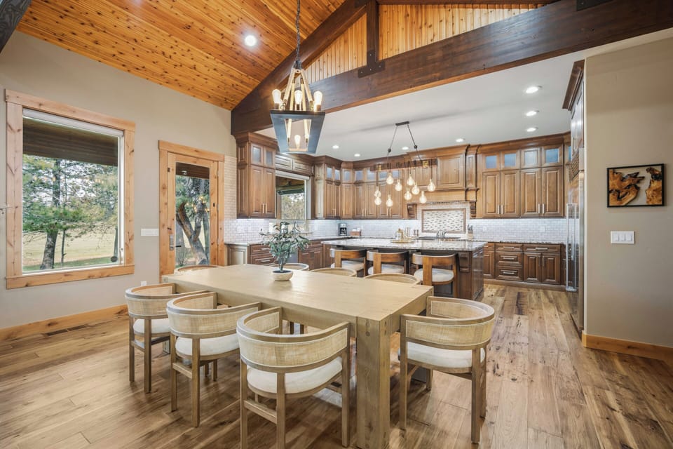 Your open-concept kitchen and dining space features rustic exposed beams, modern appliances, and garden views for memorable meals together.
