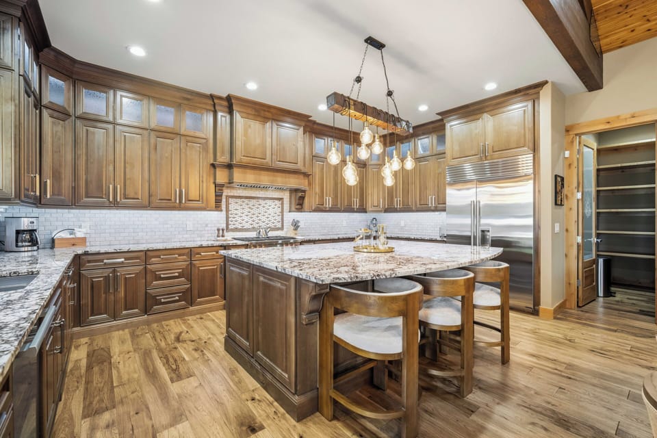 Cook your favorite meals in this stunning gourmet kitchen with granite counters, premium appliances, and a spacious island perfect for gathering.