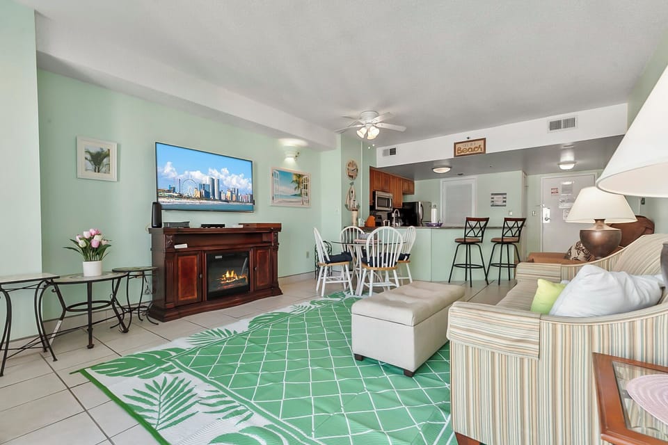 View of spacious living area with flat screen TV and dining table.