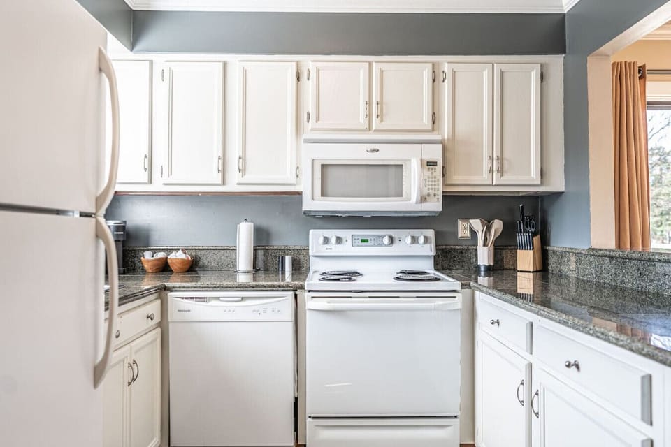Fully equipped kitchen with granite countertops, modern appliances, and plenty of space to prepare meals.