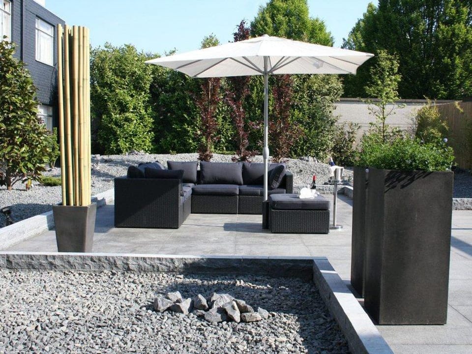 Unwind outdoors on plush seating under a shady umbrella.