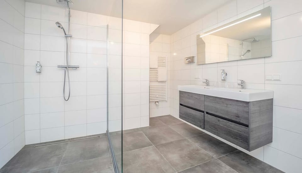 Refresh under the rainfall shower in a spotless modern bath.