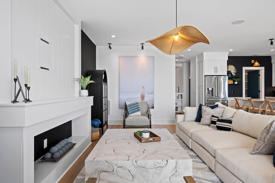 Unwind in this modern living space with cozy seating, striking pendant lighting, and a beautiful fireplace for quiet evenings.