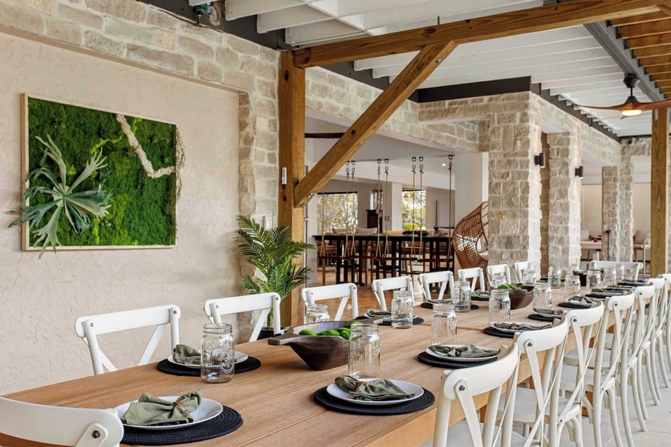 Patio Dining: Share meals at this spacious table with modern decor and lush greenery with seating for 18!