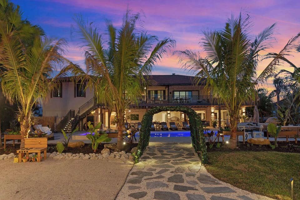 Exterior Oasis: Tropical palm trees surround a stunning pool area, perfect for sunset gatherings!