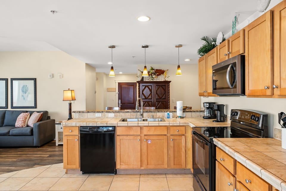 Your fully equipped kitchen flows seamlessly into the living space, perfect for preparing meals while staying connected with your group.