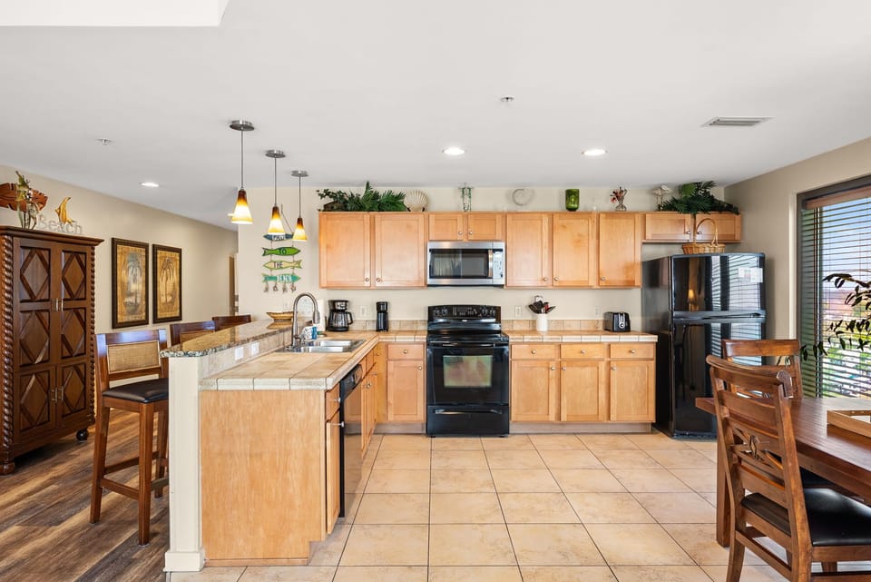 Your spacious kitchen awaits with granite counters, stainless appliances, and tropical touches that make cooking feel like a vacation.