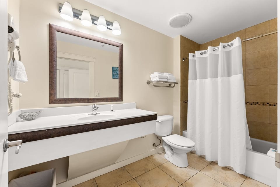 Step into your modern bathroom with fresh towels, bright lighting, and a relaxing shower waiting for you.