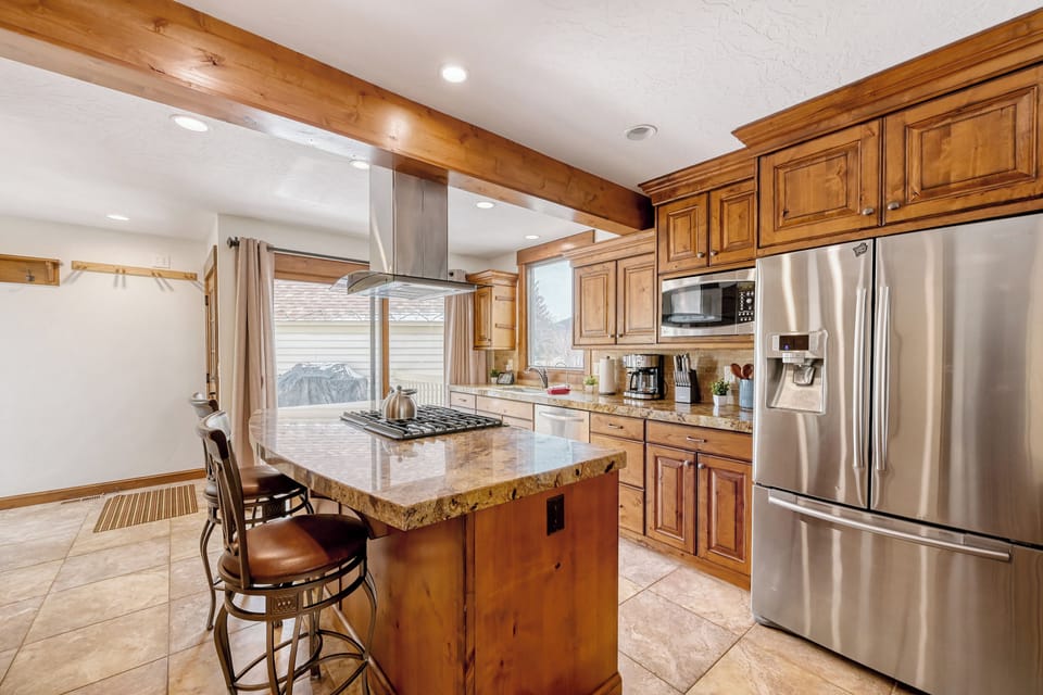 Picture yourself cooking in this warm, fully equipped kitchen with granite counters, stainless appliances, and a convenient center island. Natural light pours in, making meal prep feel effortless and inviting.