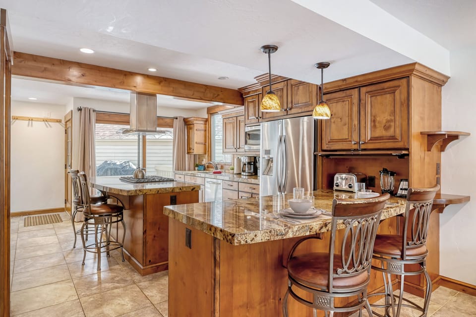 Your gourmet kitchen features warm wood cabinetry, granite countertops, and a spacious island perfect for cooking together.
