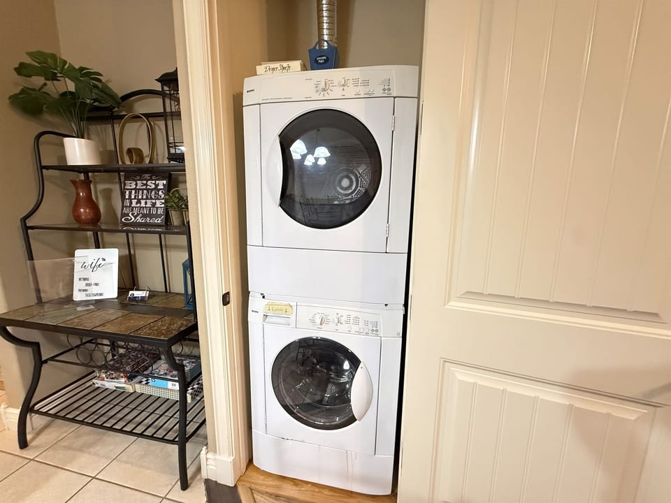 Guest laundry area featuring a stacked washer and dryer perfect for longer stays.