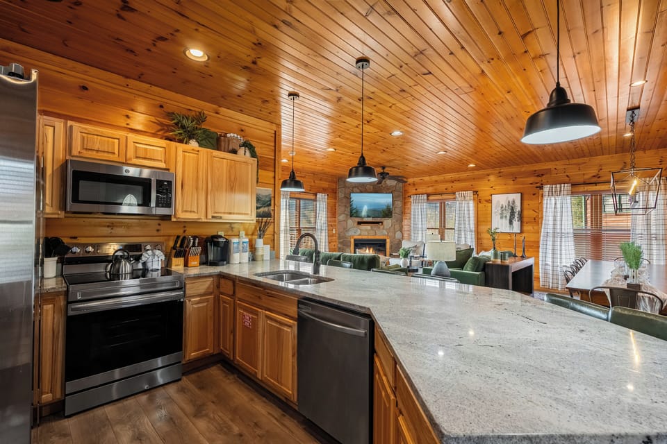 Open-concept kitchen with granite countertops and stainless steel appliances. 