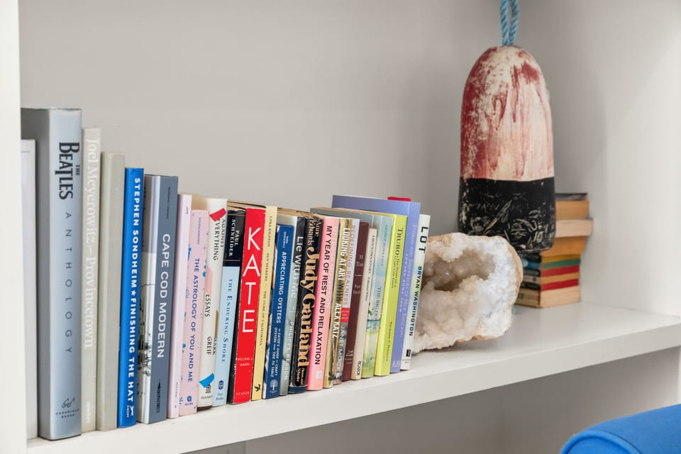 Curated bookshelf with coastal decor—perfect for cozy reads.