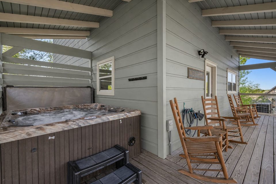 Covered deck with hot tub and rocking chairs. The perfect place to relax. 