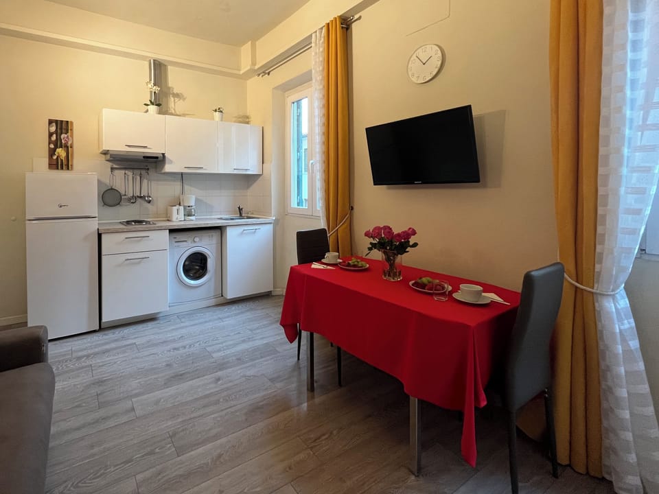 Kitchenette including large refrigerator and washing machine.
