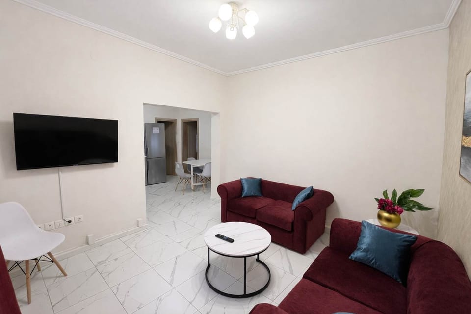 Cozy living space with sofa seating and a flat-screen TV, ideal for relaxing evenings. The open layout creates a comfortable environment for guests to unwind after visiting nearby city attractions.