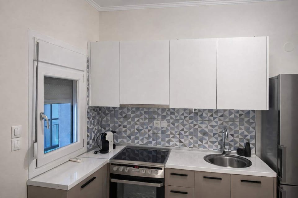 Modern kitchen with stove, oven, refrigerator, and essential cookware, perfect for preparing meals during your stay.