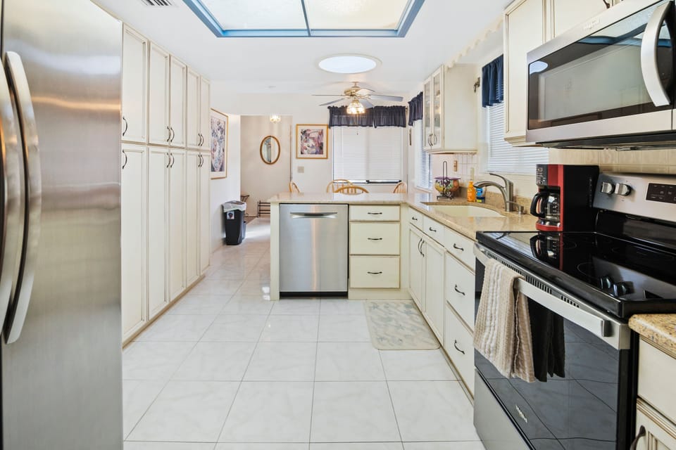 Bright, spacious kitchen with stainless steel appliances, ample cabinetry, and a breakfast nook—perfect for easy meals during your beach stay. Enjoy the comfort of home while vacationing near the shore.