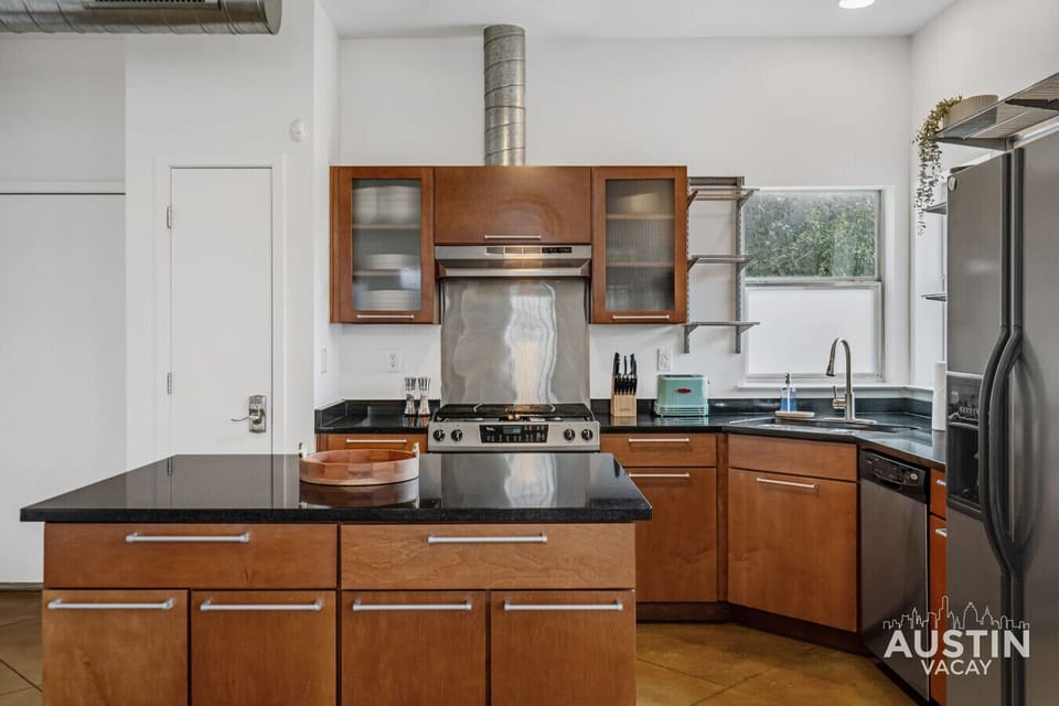 Full kitchen view with gas range, stainless appliances, and center island.