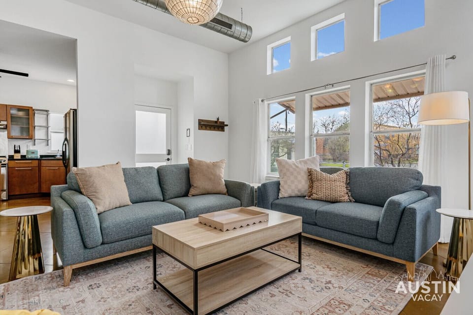 Conversation setup with matching sofas and natural light from tall windows.