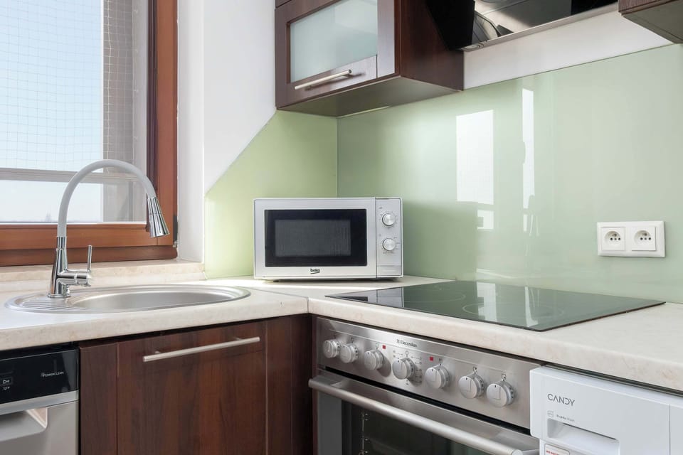 A closer view of the kitchen work area with a stove and oven. Cabinets and drawers offer organized storage for kitchen tools.