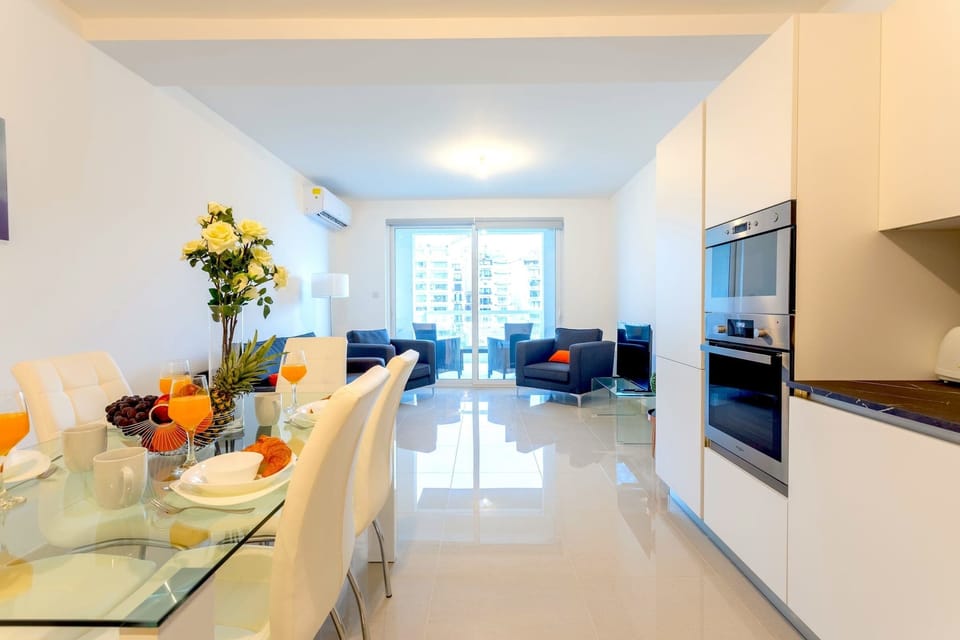The open-plan living, dining and kitchen area with access to the balcony.