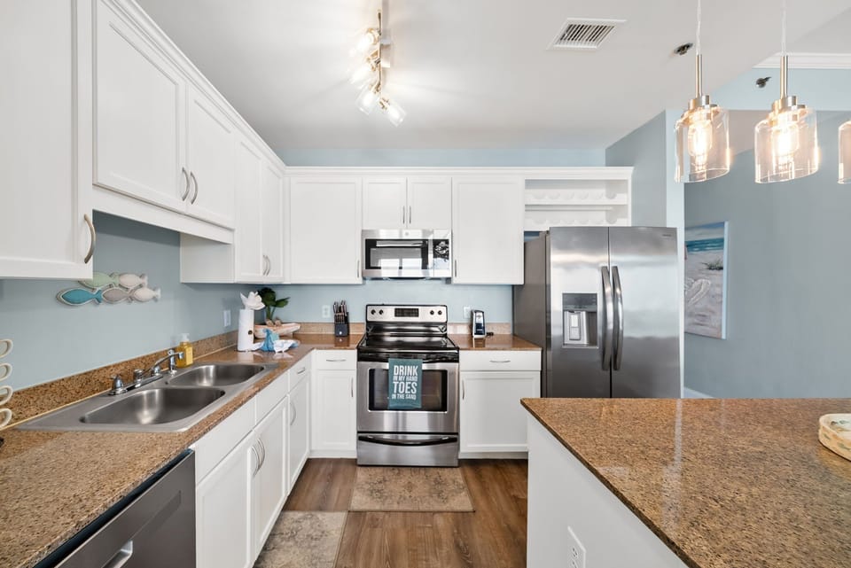 Your fully-equipped kitchen awaits with stainless appliances, granite counters, and coastal touches that make meal prep a joy.