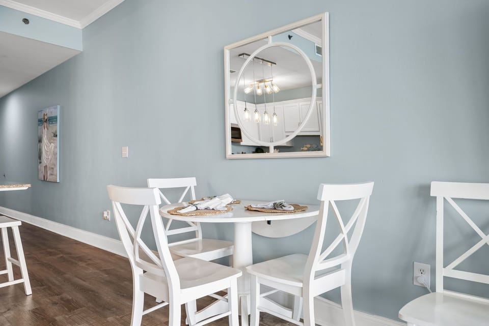 Gather around this charming white dining table in your coastal-inspired space, where soft blue walls create a peaceful atmosphere for memorable meals.