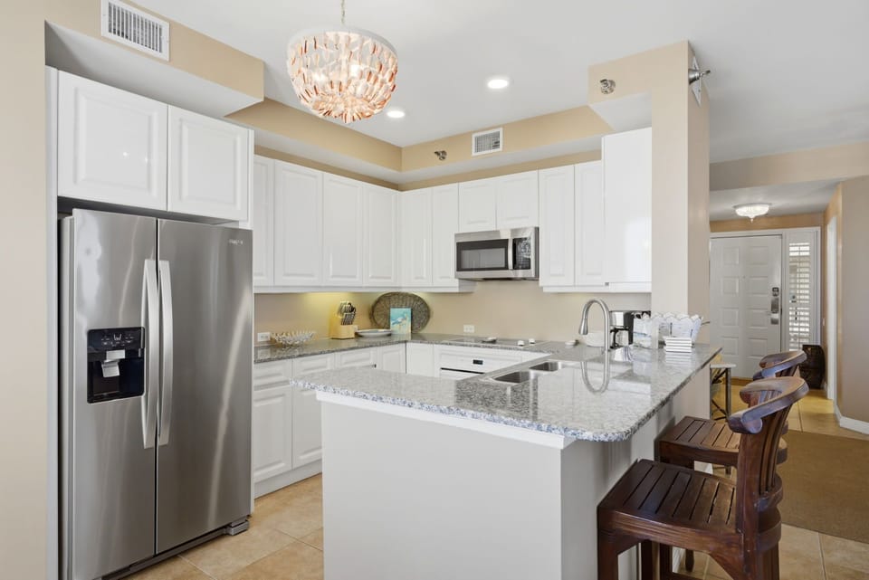 Beach Colony T PH1D- Your fully equipped kitchen features modern stainless appliances, granite counters, and a breakfast bar where you can gather for morning coffee or plan your day's adventures together.