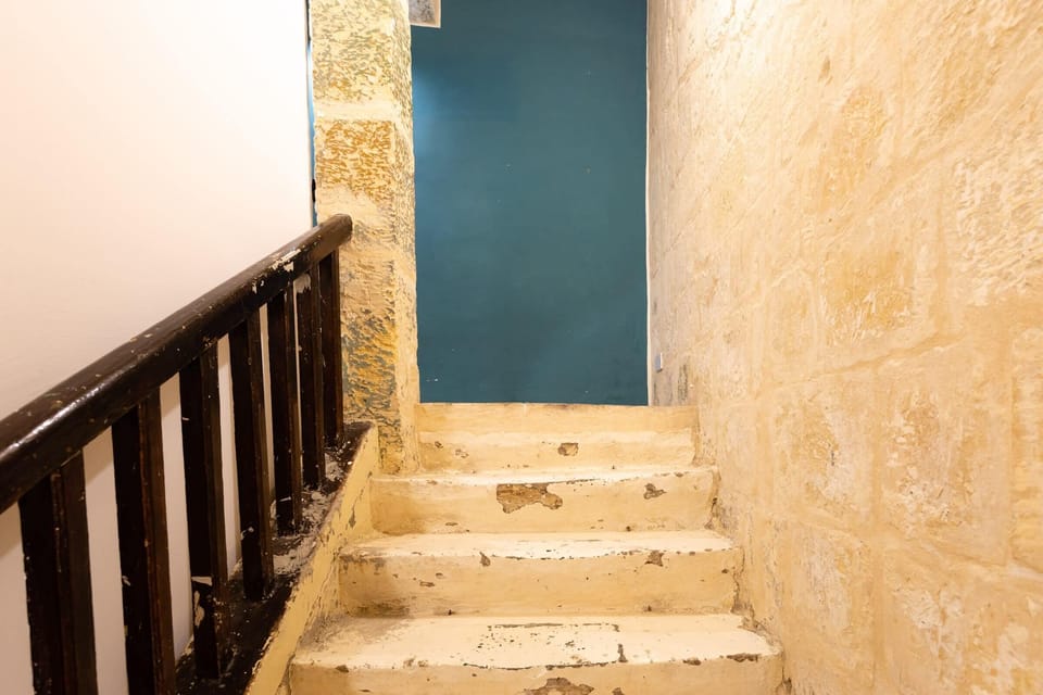 The stairs leading down to the first floor and bedroom