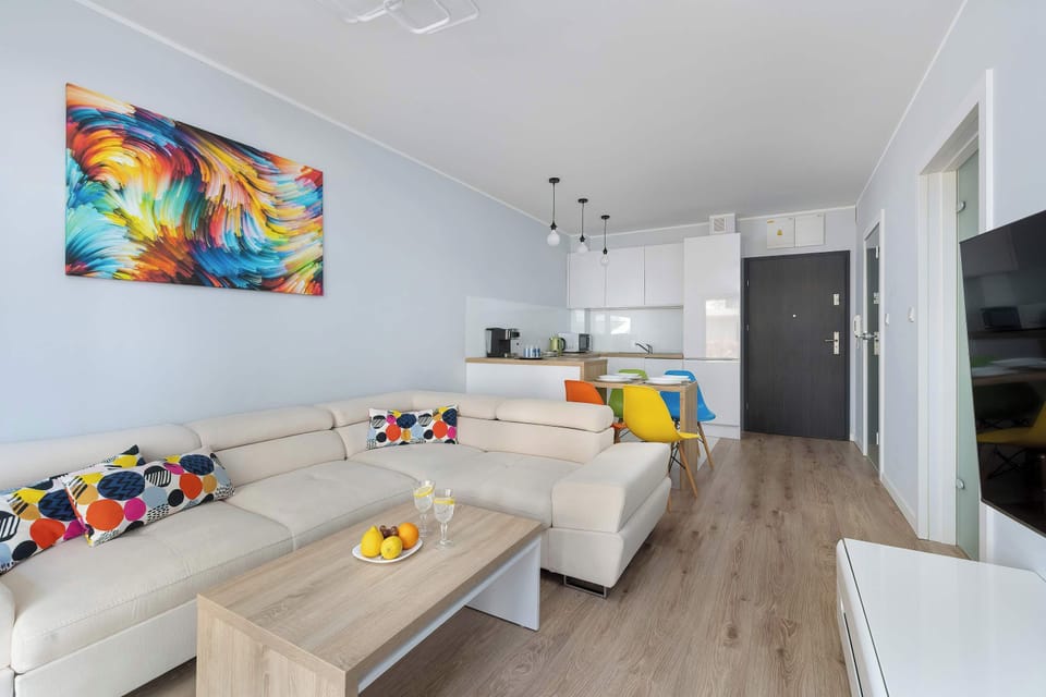An inviting interior perspective shows the transition from the colorful living room to the hallway. A large, abstract piece of art on the wall adds a bold splash of color to the neutral palette.