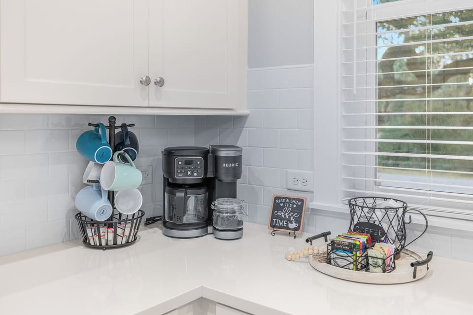 Coffee station with drip maker, pods, and mugs ready