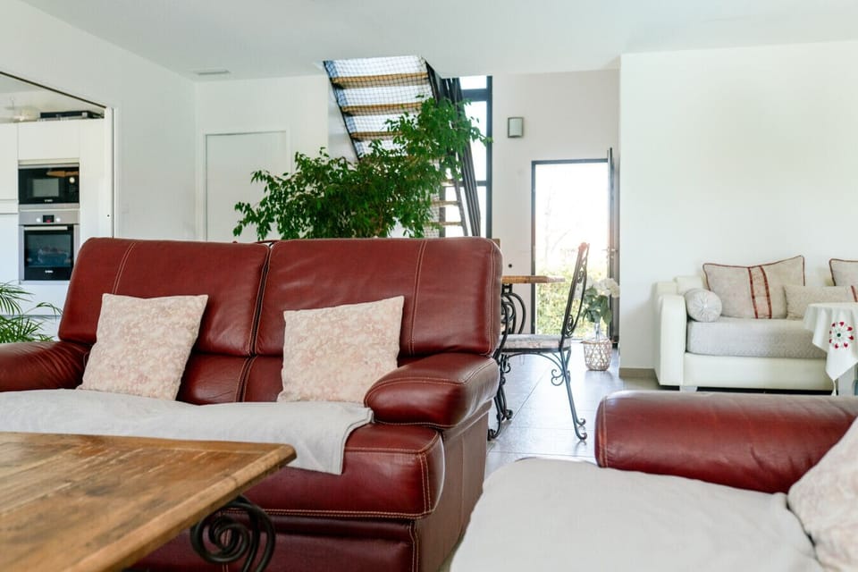 Hall et séjour de la villa – espace clair et aéré, plante tropicale, escalier et vue sur le coin salon