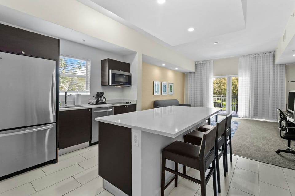 Modern kitchen featuring a spacious island, stainless steel appliances, and seating for casual dining.