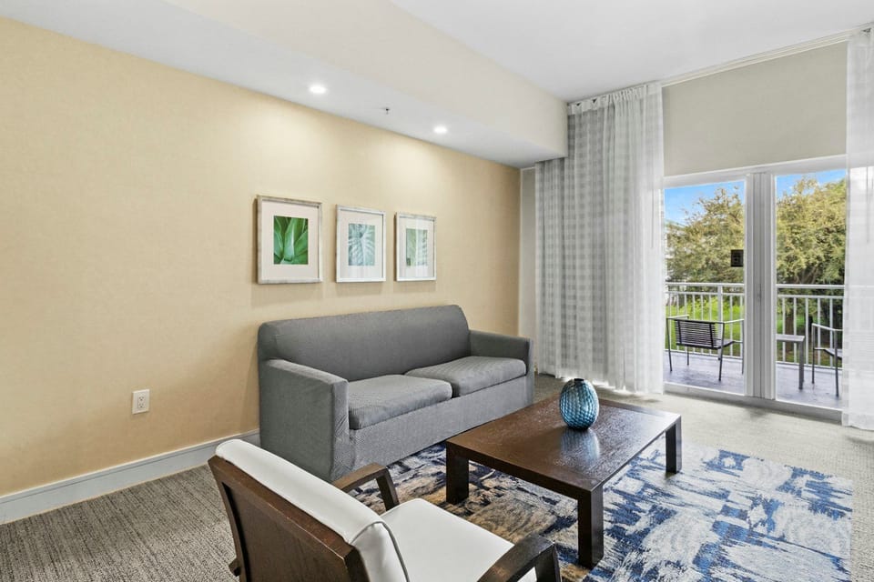 Bright living area with a comfortable sofa, modern décor, and direct access to the private balcony.