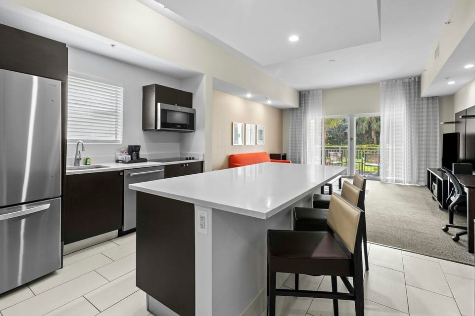 Sleek kitchen with a large island, stainless steel appliances, and seating for casual dining.