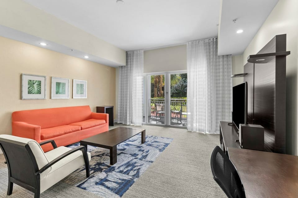 Inviting living area with modern seating, soft natural light, and easy access to the private balcony.