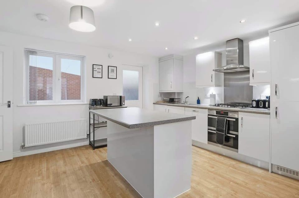 Modern Kitchen: A bright and spacious kitchen featuring modern appliances, ample workspace, and a central island — perfect for cooking, preparing meals, or socialising while dining.