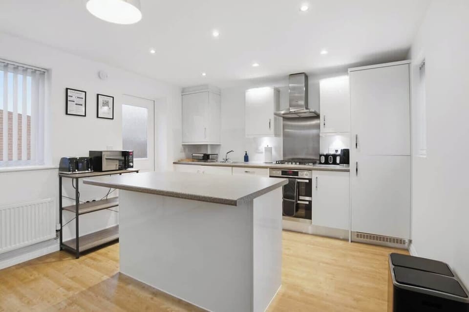 Modern Kitchen: A bright and spacious kitchen featuring modern appliances, ample workspace, and a central island — perfect for cooking, preparing meals, or socialising while dining.