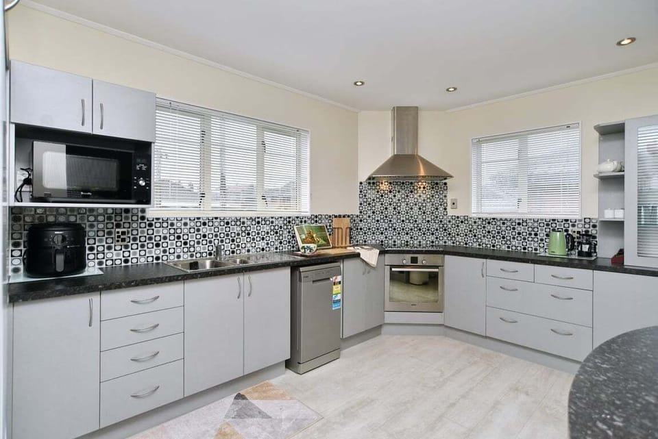 Everything needed to cook a proper meal — oven, hob, dishwasher, full-size fridge, generous bench space.