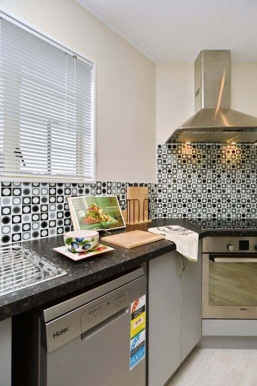 Living, dining, and kitchen open into each other — whoever is cooking stays part of what is happening.