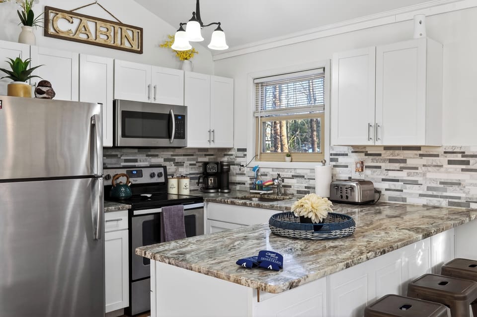 Kitchen detail showing the microwave, stove, and tile backsplash.