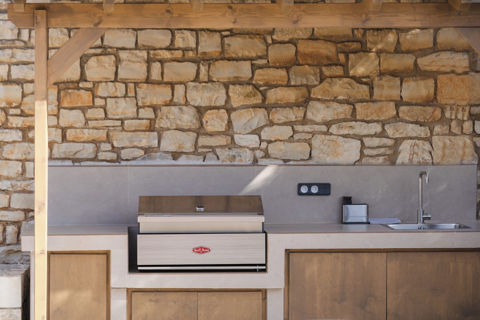 Fully equipped barbecue facilities with a charcoal grill and an outdoor sink.