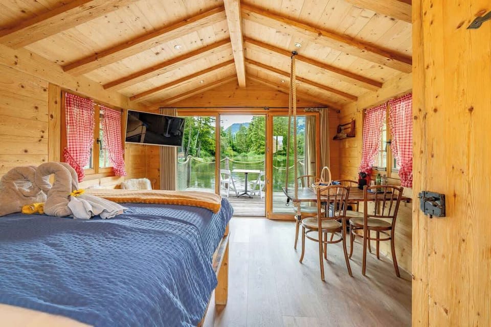 Open-plan interior with bed, dining area, and terrace access
