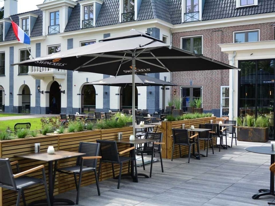 Sip morning coffee under umbrellas in relaxed outdoor seating.
