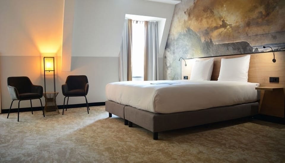 Unwind in a serene bedroom with plush bedding and art.
