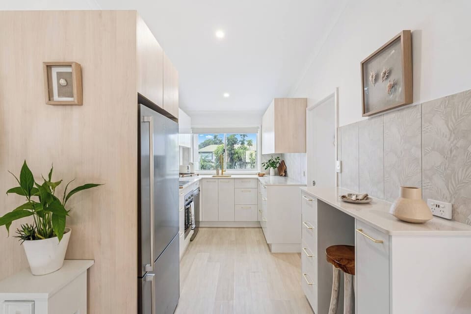 A minimalist desk nook in the kitchen, designed as a casual workspace for catching up on emails or planning the day.