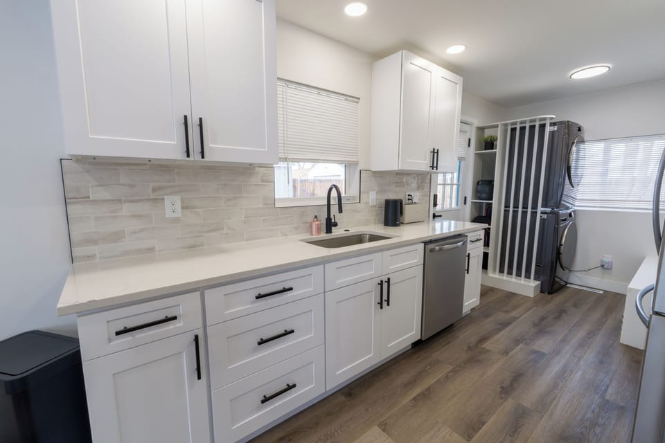 Your fully equipped kitchen features sleek white cabinets, modern appliances, and ample counter space for preparing memorable meals during your stay.